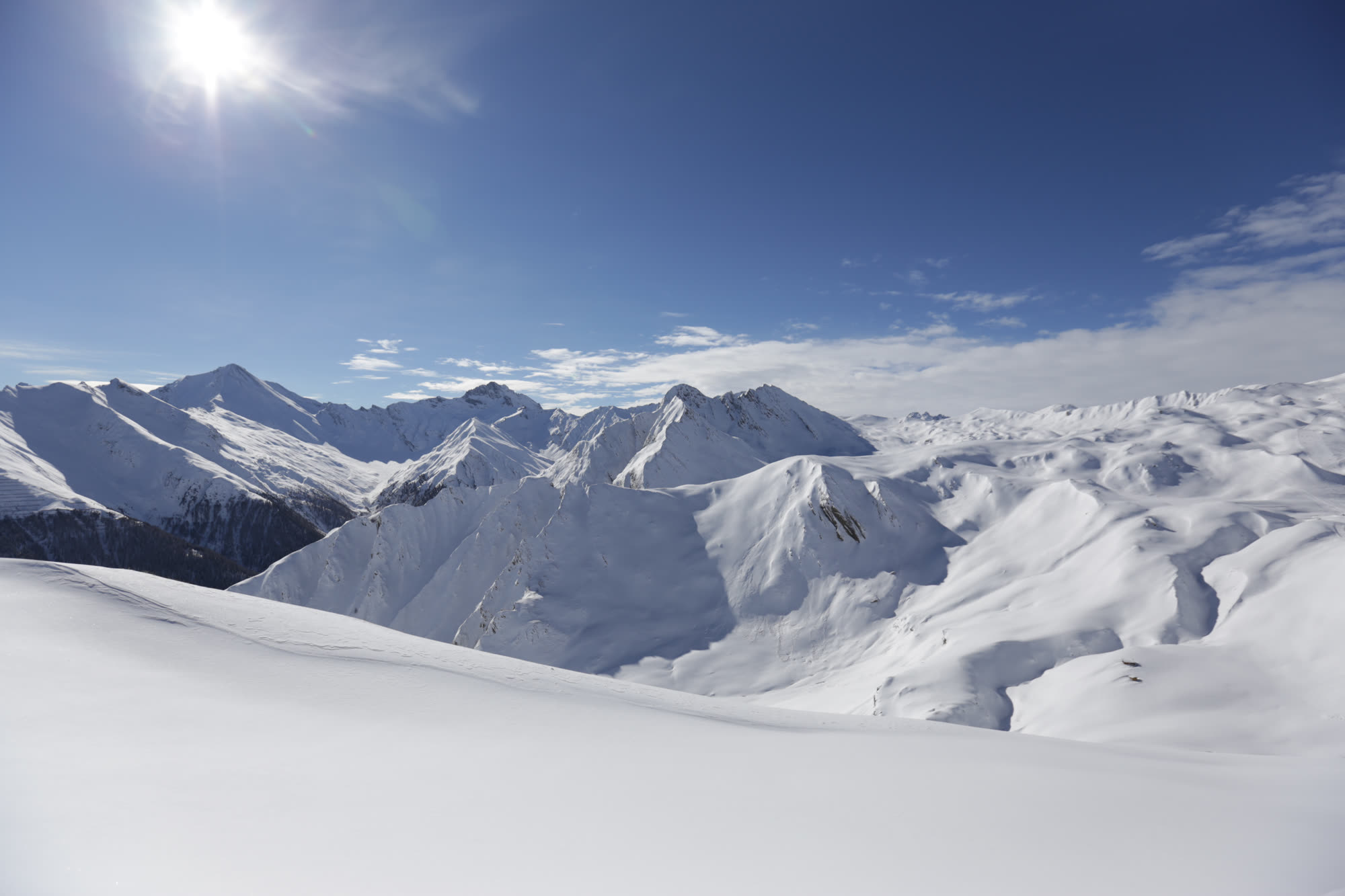 Verschneite Berglandschaft im Samnaun unter blauem Himmel