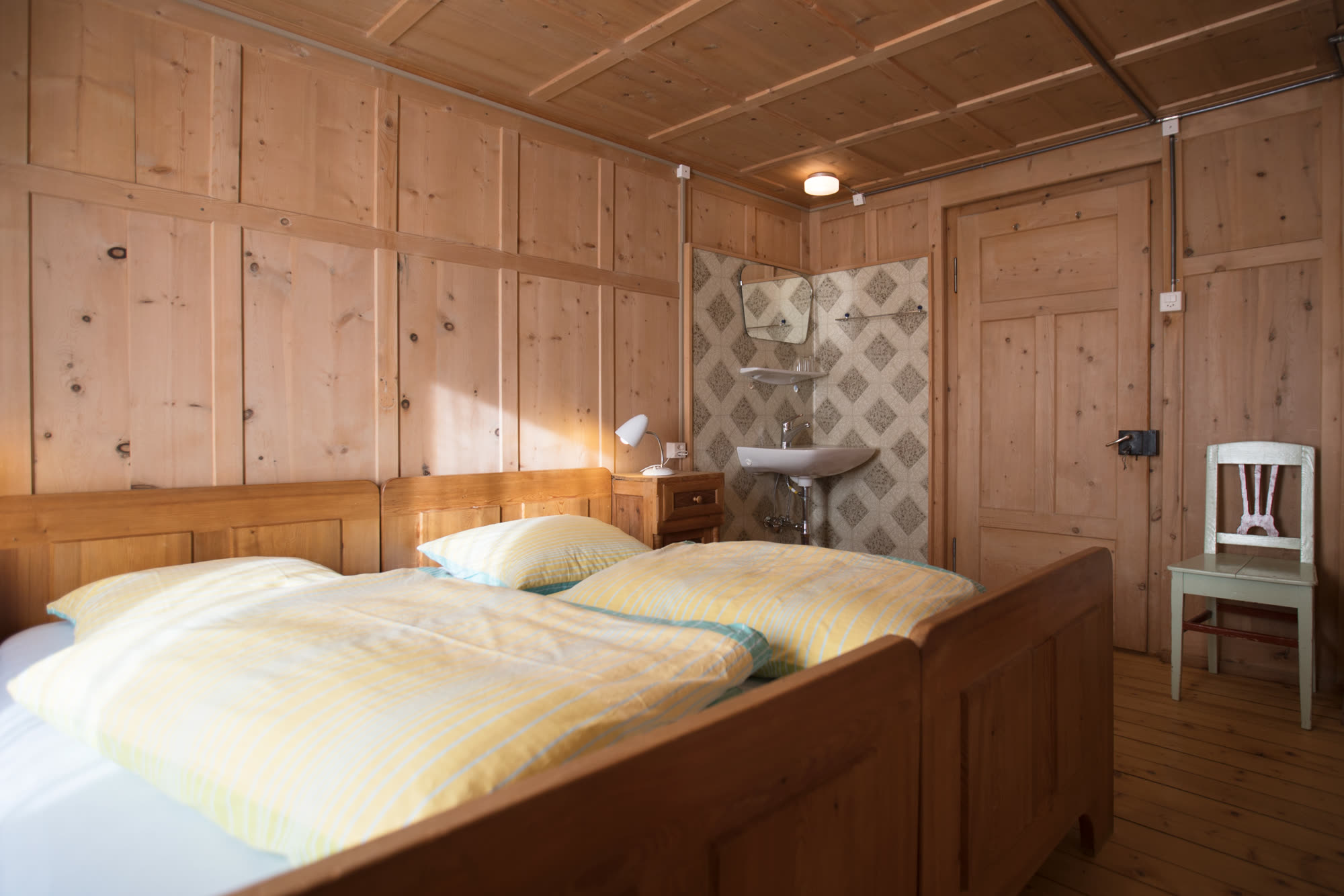 Schlafzimmer mit Doppelbett und Lavabo