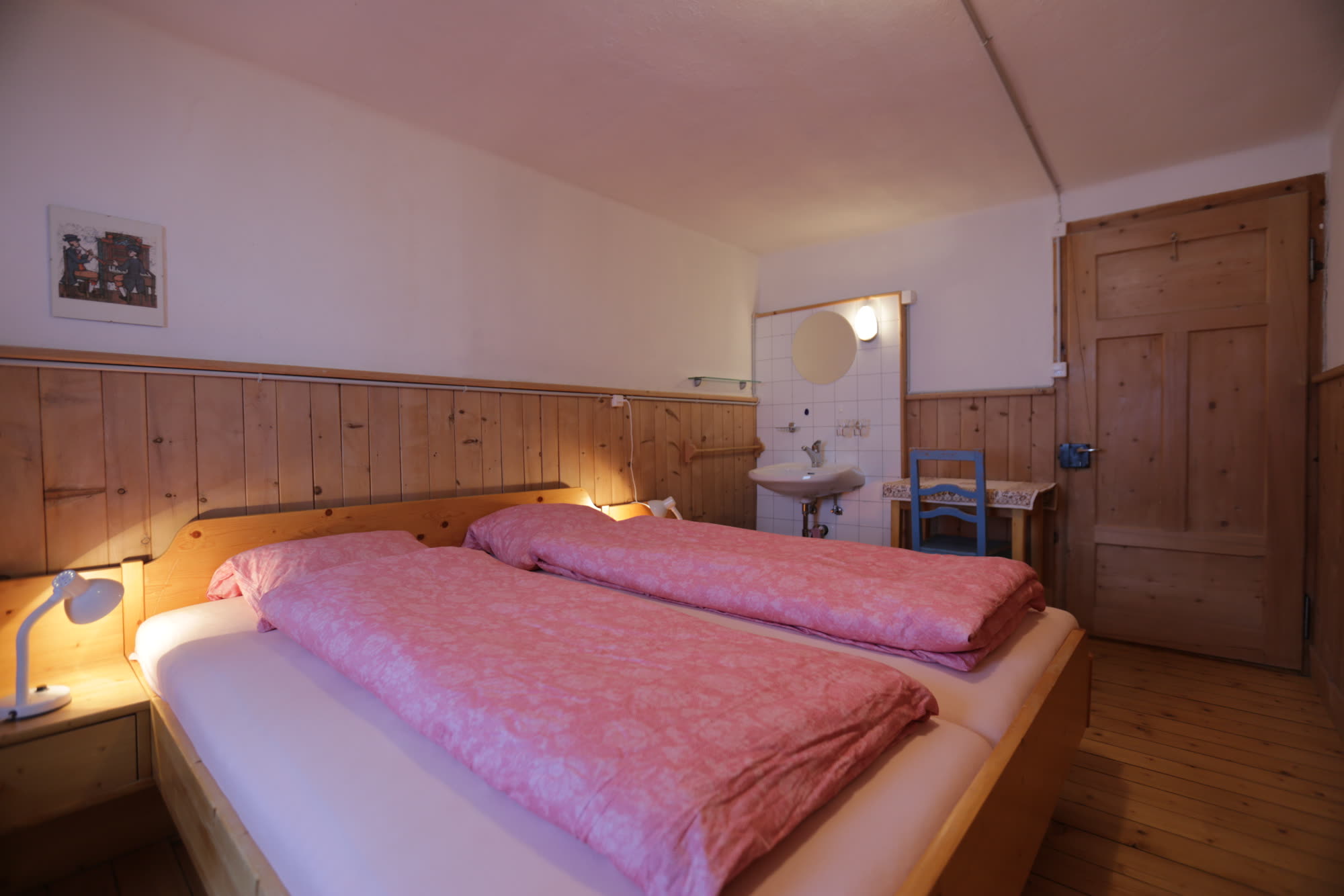 Schlafzimmer mit Doppelbett und Lavabo